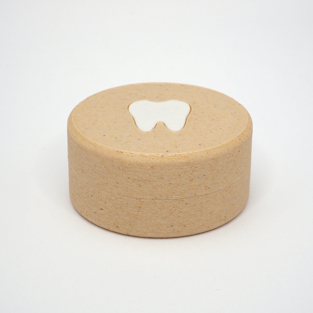 Packshot af lille tandfe æske til mælketænder, set forfra med låg og tandmotiv på toppen