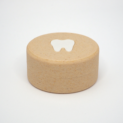 Packshot af lille tandfe æske til mælketænder, set forfra med låg og tandmotiv på toppen