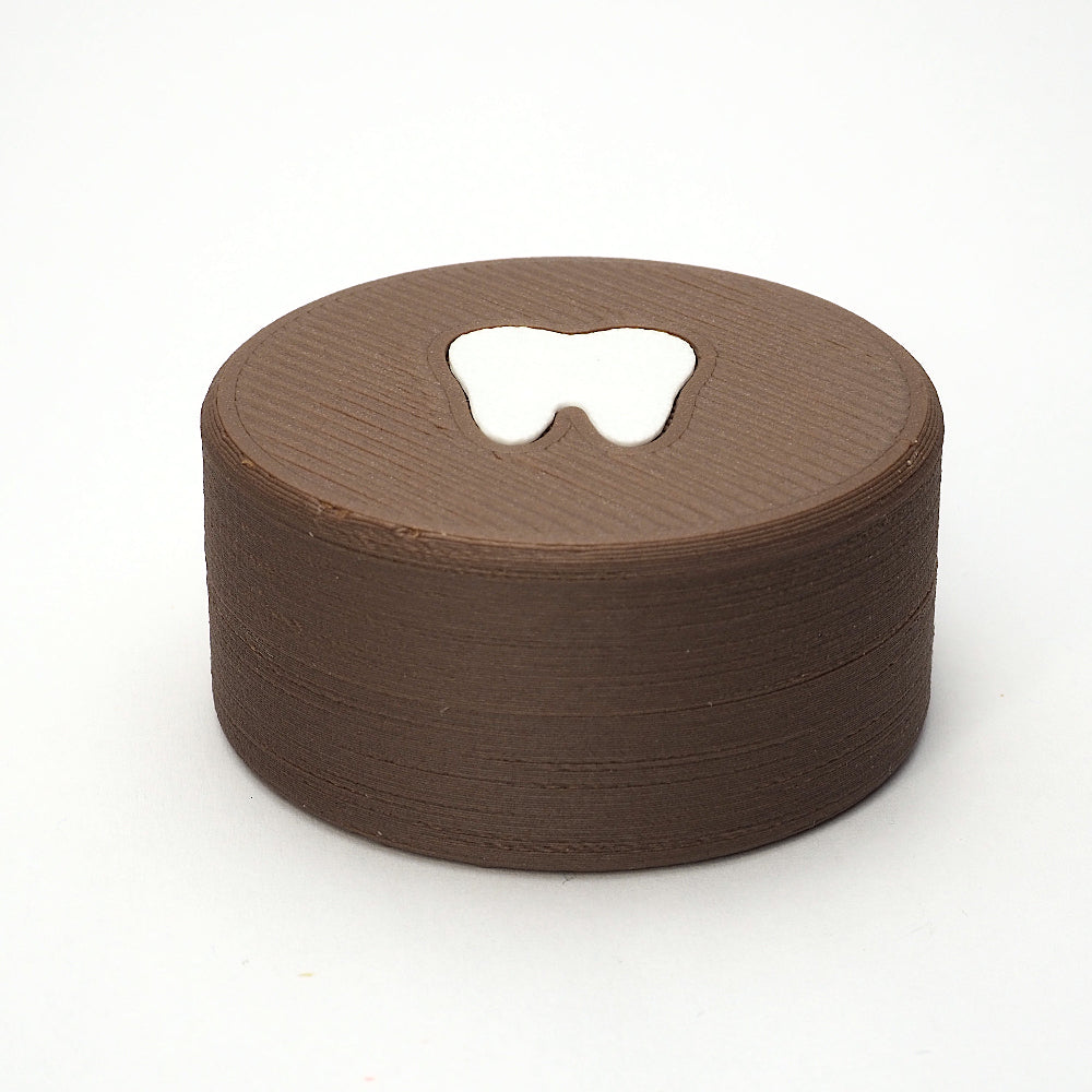 Packshot af lille tandfe æske til mælketænder, set forfra med låg og tandmotiv på toppen